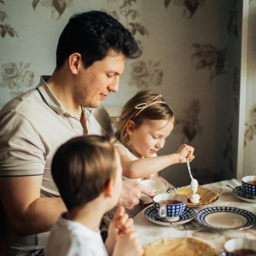 Father helping children make food